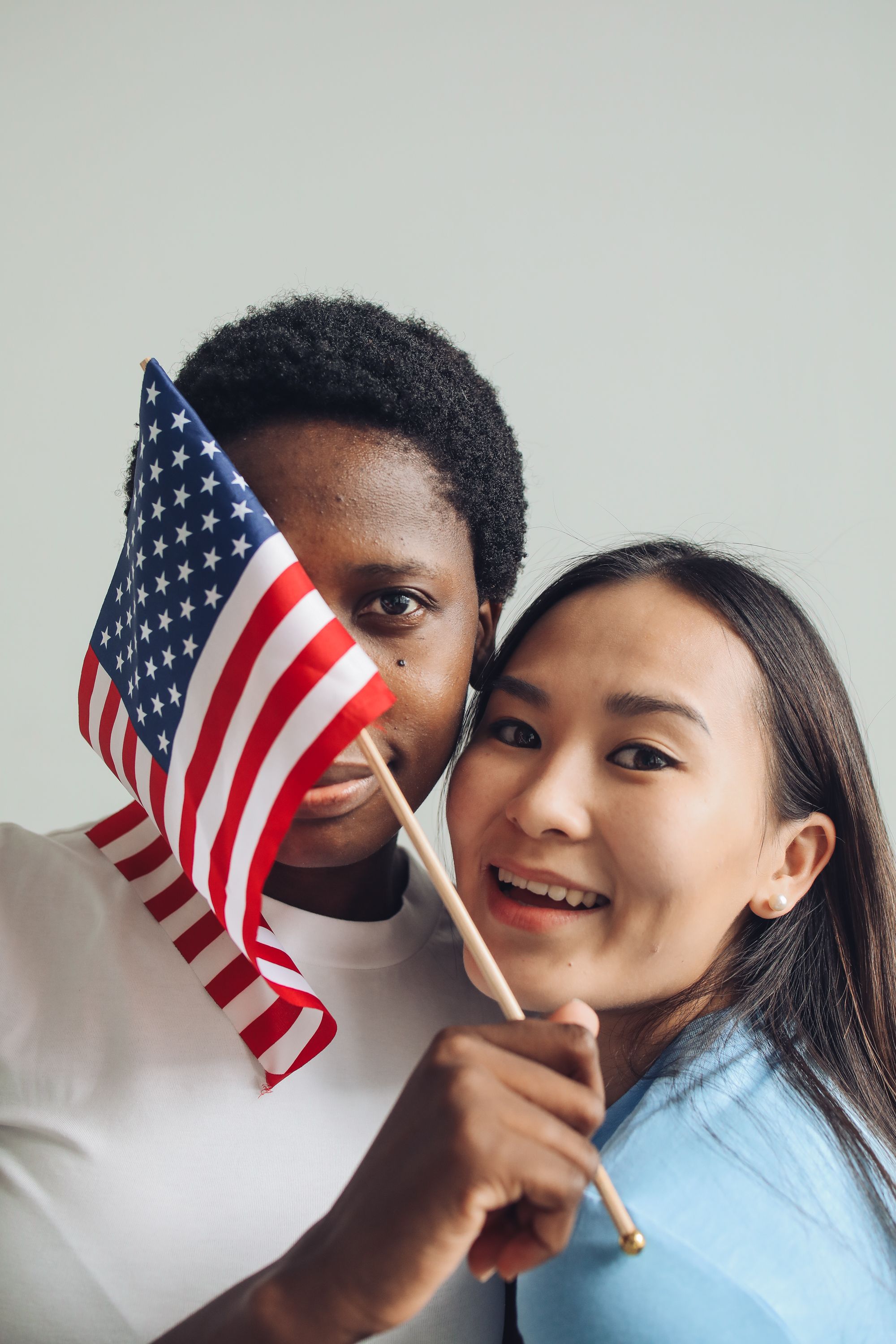 Two people smiling with a small American flag