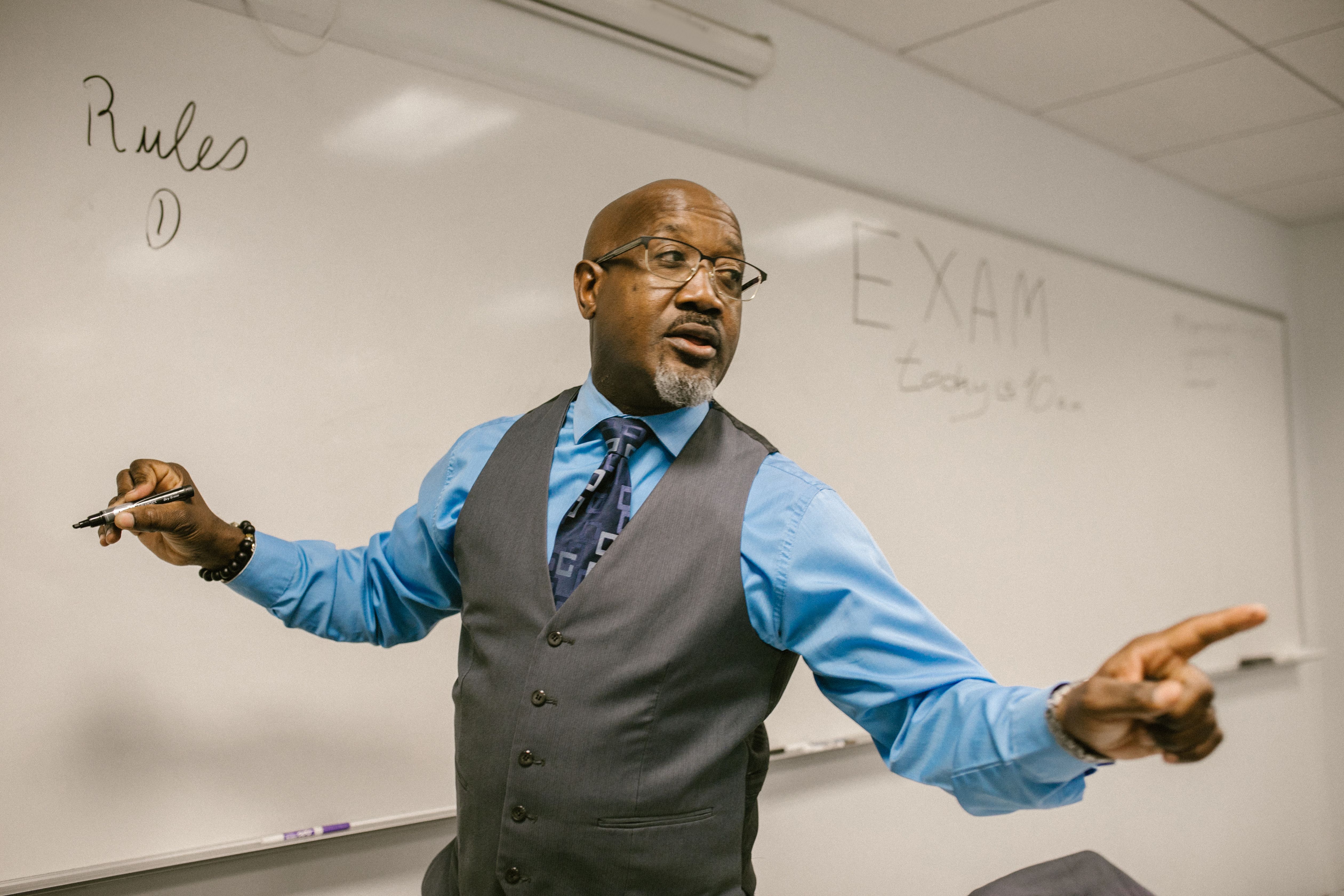 Instructor teaching from a classroom whiteboard